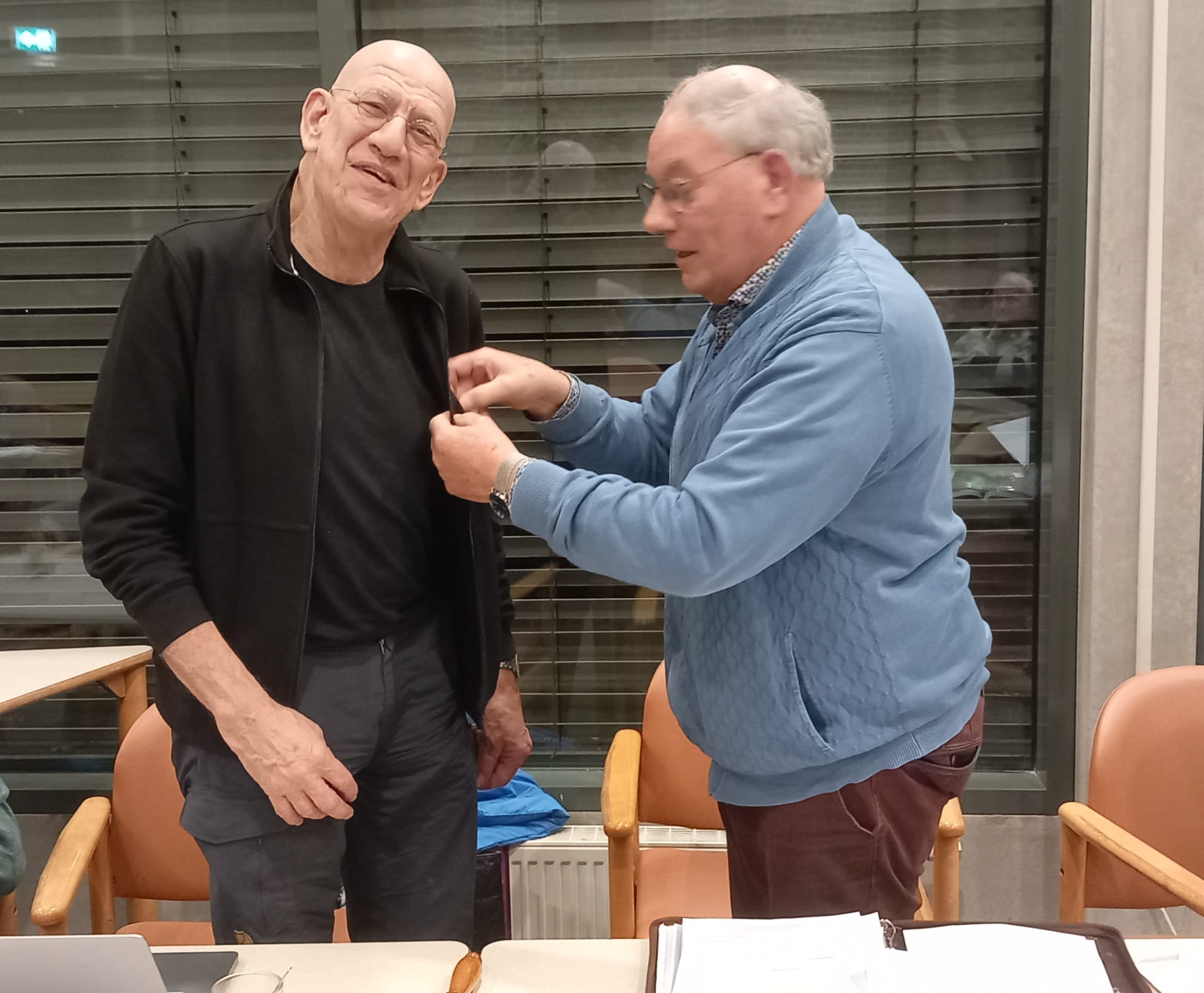 Huldiging Maurice Gemmeke voor zijn 12.5 jarig lidmaatschap en zijn afscheid als penningmeester van de vereniging. Op de foto voorzitter Martin Burghout die Maurice het speldje op spelt.